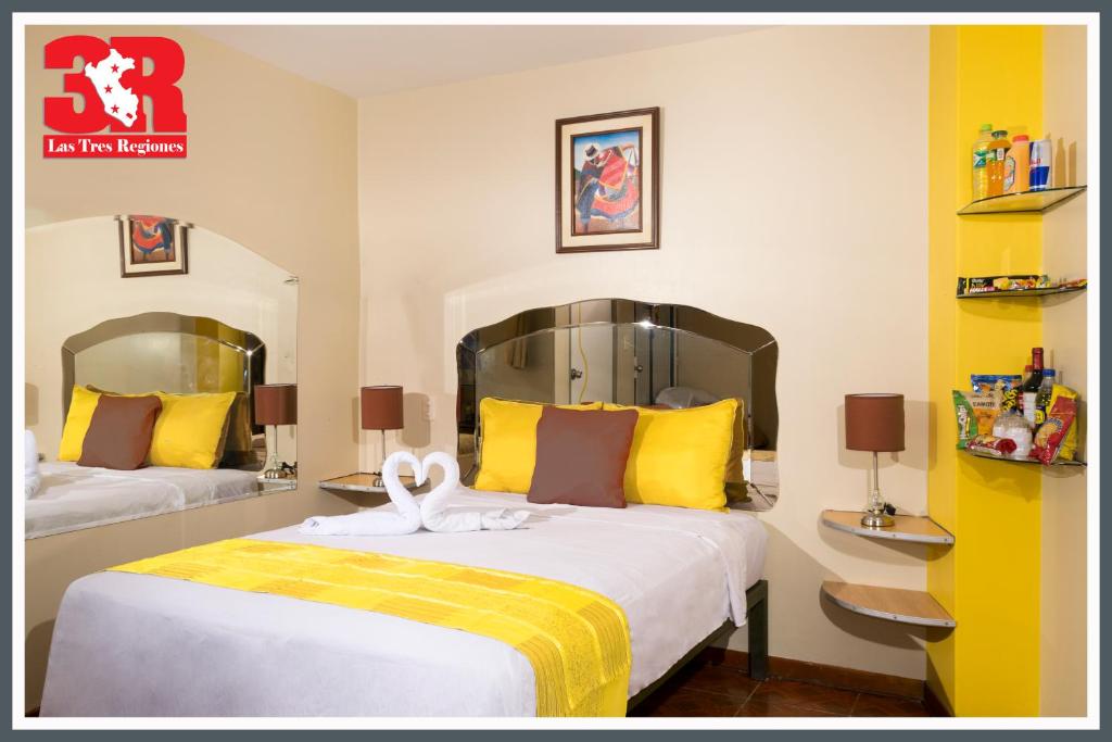 a bedroom with two beds with yellow and white at Hospedaje Las Tres Regiones in Lima