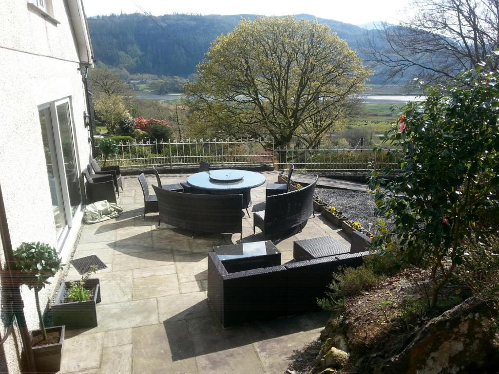 a patio with couches and a table and chairs at Snowdonia Mawddach escape in Dolgellau