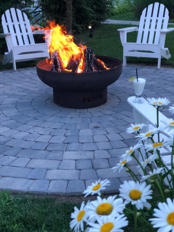 eine Feuerstelle mit zwei weißen Stühlen und Blumen in der Unterkunft Hotel Dylan in Woodstock