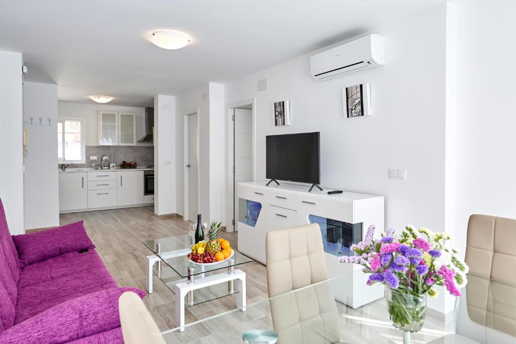 sala de estar con sofá púrpura y mesa en Sonrisa Apartments, en Benidorm