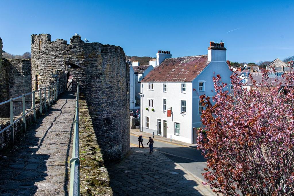 a castle with two people walking down a street at Number 18 in Conwy