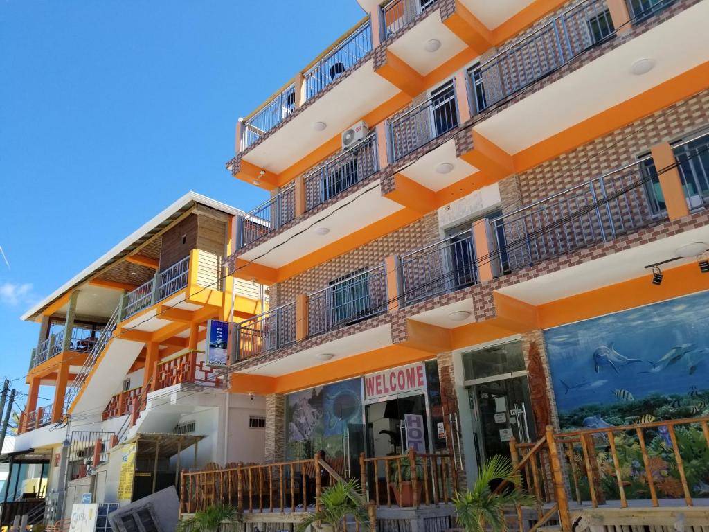 an apartment building with balconies and a store at Enjoy Hotel in Caye Caulker