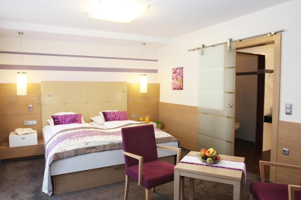 une chambre d'hôtel avec un lit et une chaise dans l'établissement Hotel Lenauhof, à Bad Birnbach