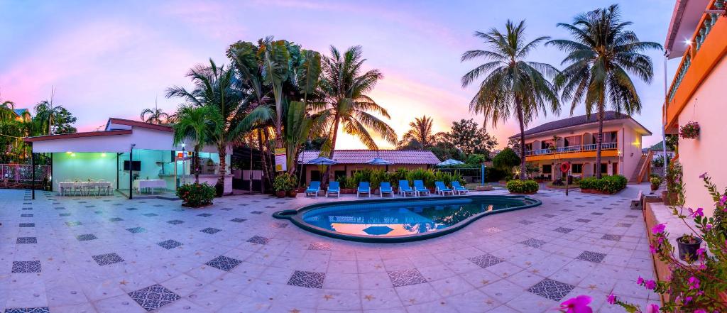 un complejo con piscina en un patio con palmeras en Coconut Resort Hotel en Patong