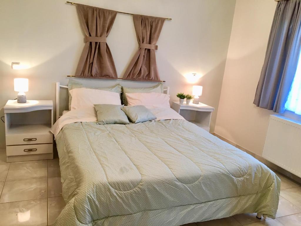 ein Schlafzimmer mit einem großen Bett mit zwei Nachttischen in der Unterkunft Luxury House in Nafplio with a great view balcony in Nafplio