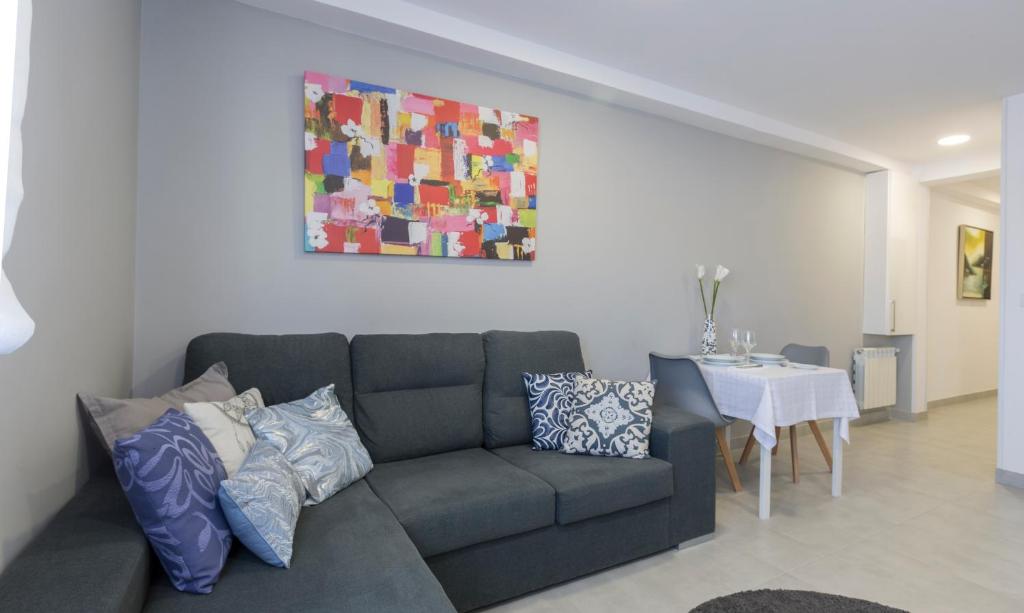Alameda Home Pontevedra في بونتيفيدرا: غرفة معيشة مع أريكة وطاولة