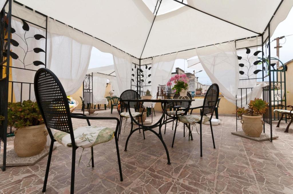 un patio con sillas y una mesa en una tienda de campaña en Fiori e Coccole, en Noto