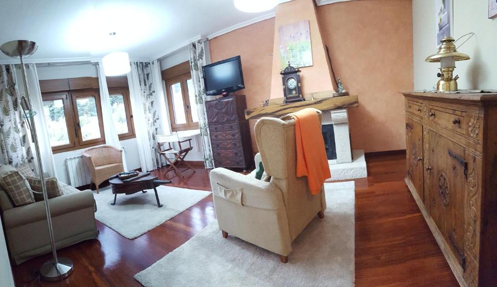 a living room with a chair and a fireplace at Apartamentos El Sol in Potes