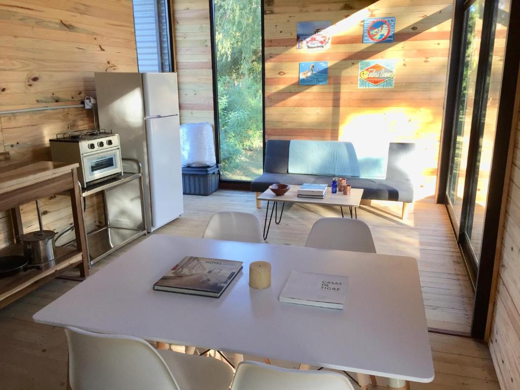 a kitchen with a white table and chairs in a room at Cabañas Isla San Jose in Tigre