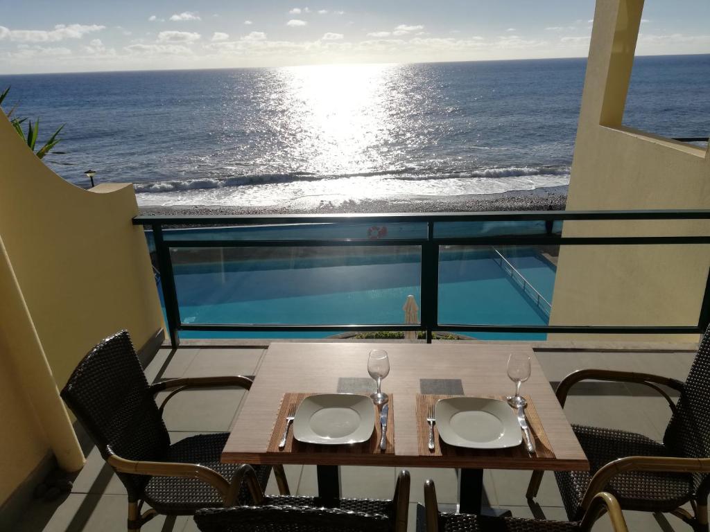 una mesa y sillas con vistas al océano en By the Beach & Pool Apartment, en Funchal