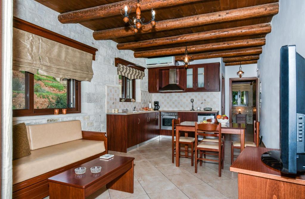 eine Küche und ein Wohnzimmer mit einem Tisch und Stühlen in der Unterkunft Ariadni Apartments in Sfinárion