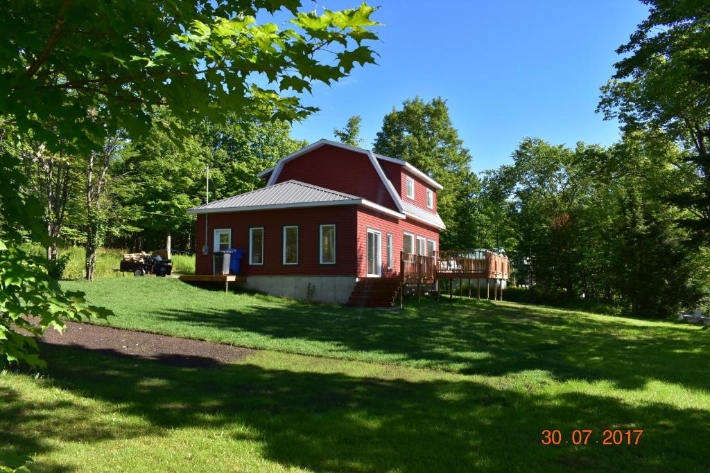 a red house in the middle of a yard at Domaine Henri-Daze in Saint-Pierre-Baptiste
