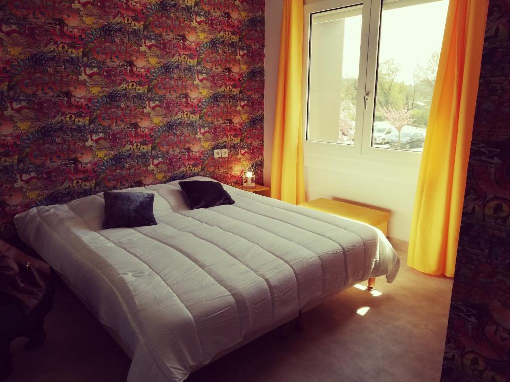 een slaapkamer met een bed in een kamer met een raam bij Les gîtes du Thouet in Saint Loup Lamaire