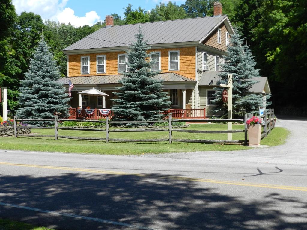 a house with a fence in front of it at Waybury Inn in East Middlebury