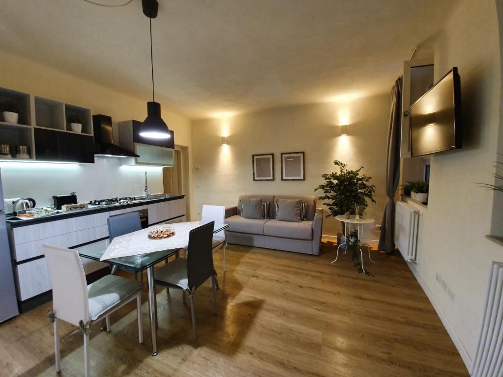 Il comprend une cuisine et un salon avec une table et un canapé. dans l'établissement 6 Via della Rosa, à Lucques