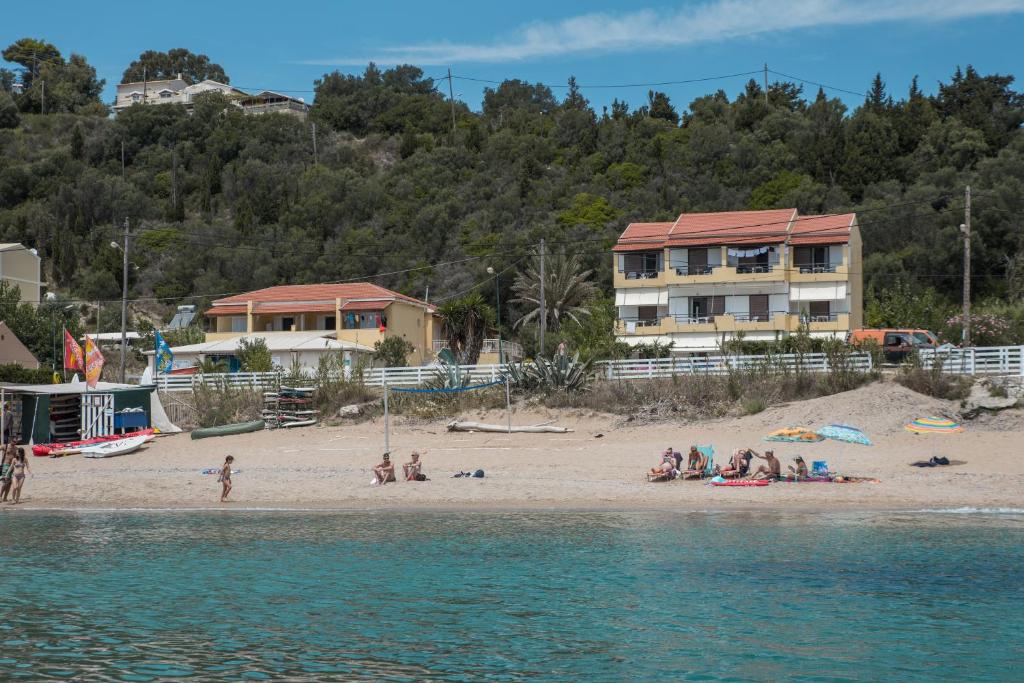 a group of people on a beach near the water at ELIAS & VASILI HOUSE in Agios Georgios Pagon