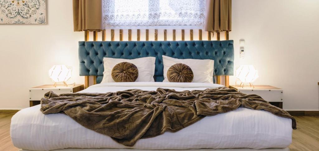Schlafzimmer mit einem großen Bett mit blauem Kopfteil in der Unterkunft Dome Rooms Downtown in Chania