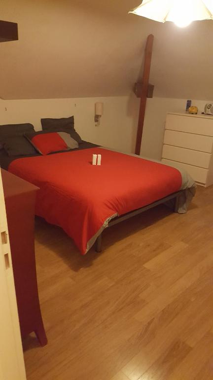 a bedroom with a red bed with a cross on the wall at Villa du Courboulay in Sargé Les Le Mans 