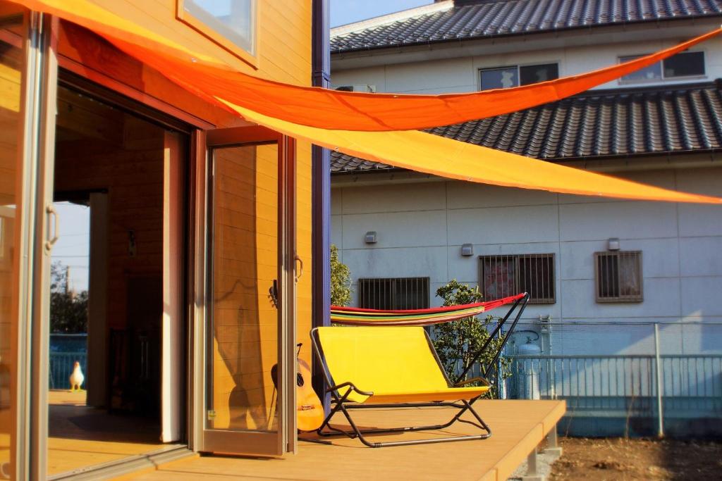 une chaise jaune sur une terrasse couverte à baldaquin orange dans l'établissement BALLAD HOUSE / Vacation STAY 27536, à Yachimata