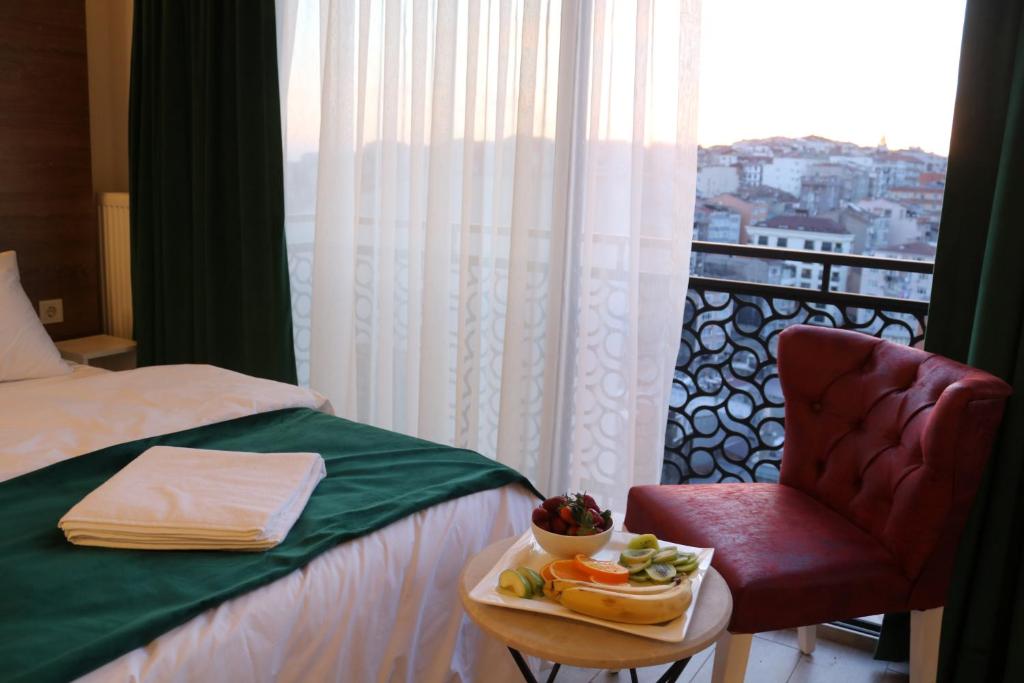 イスタンブールにあるMusk Hotelのベッド1台、椅子、食料品のトレイ付