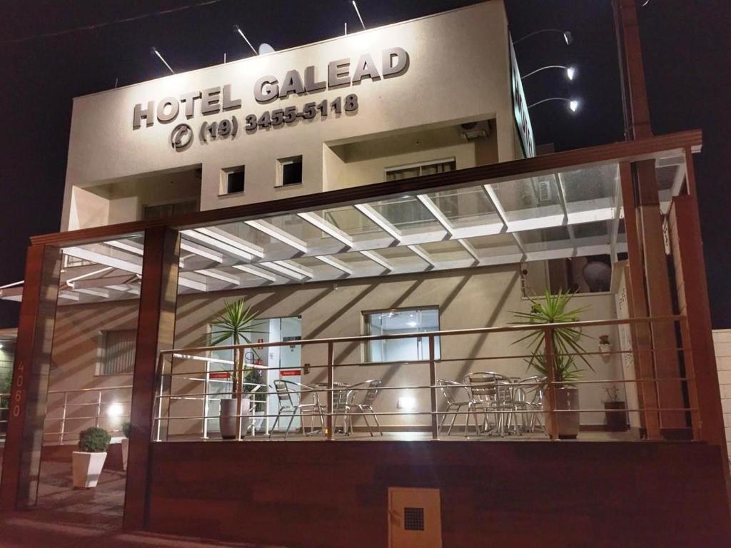 un hôtel appelé galerie d'hôtel avec des tables et des chaises dans l'établissement Hotel Galead, à Santa Bárbara dʼOeste