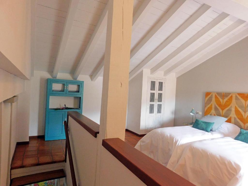 a bedroom with a bed and a blue cabinet at Alborada Apartamentos Rurales in Hervás