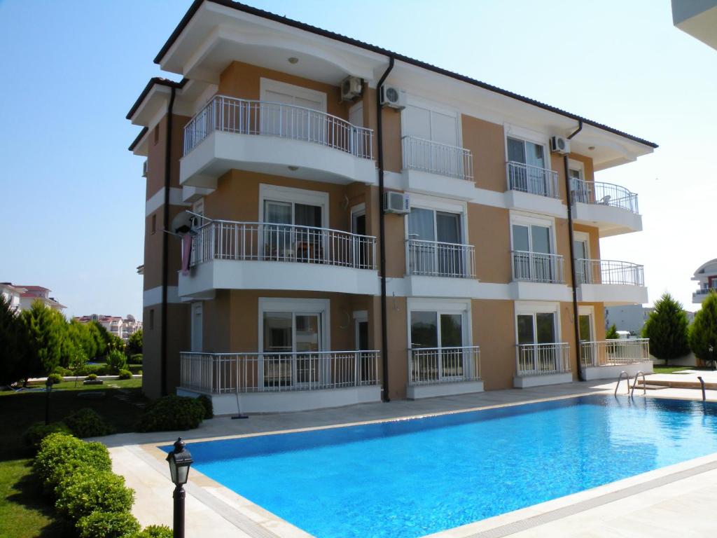un edificio con piscina frente a él en Antalya belek sama river golf apart second floor 2 bedrooms pool view close to center, en Belek