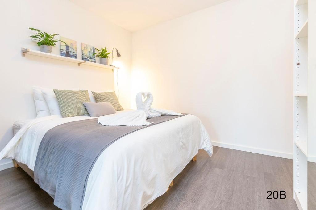 a white bedroom with a large bed in a room at Newly build Loft heart city center Delft in Delft
