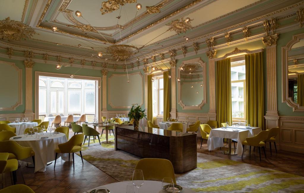 a dining room with tables and chairs and a ceiling at Vila Foz Hotel & SPA - member of Design Hotels in Porto