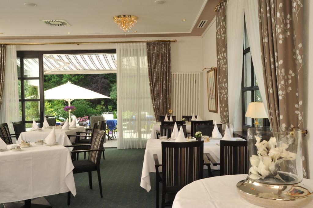a restaurant with tables and chairs with white table cloth at Hotel Spiegel in Cologne