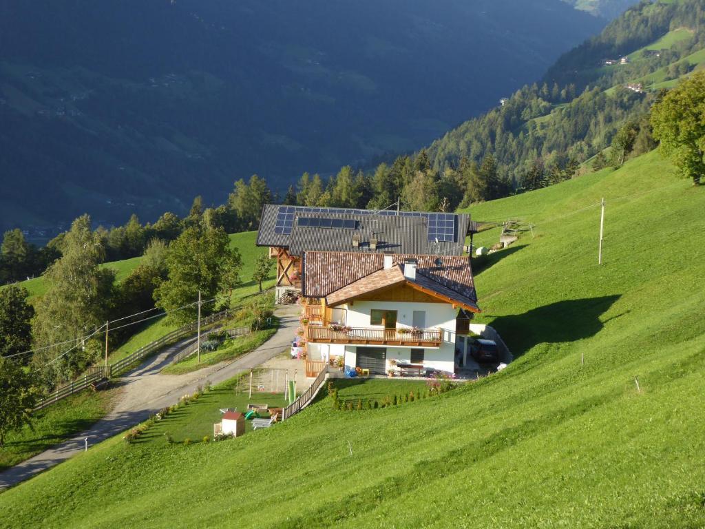 ein Haus auf einem Hügel mit Solardach in der Unterkunft Ferienwohnungen Ederhof in Schenna