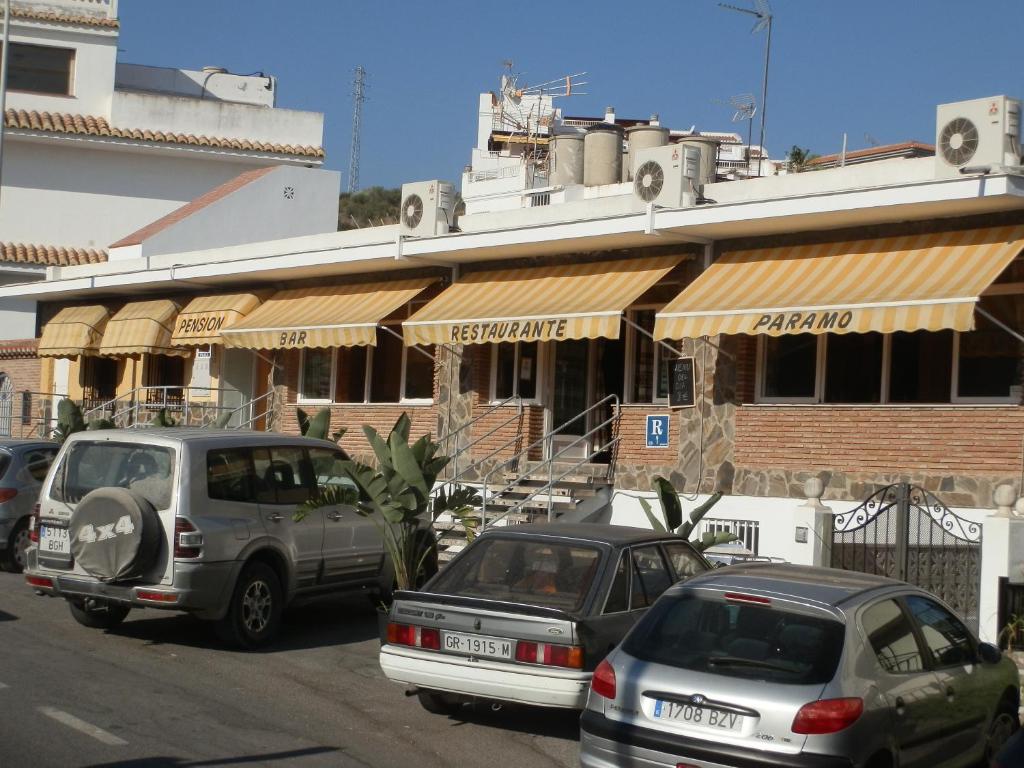 un groupe de voitures garées devant un bâtiment dans l'établissement Pensión Restaurante Páramo, à La Herradura