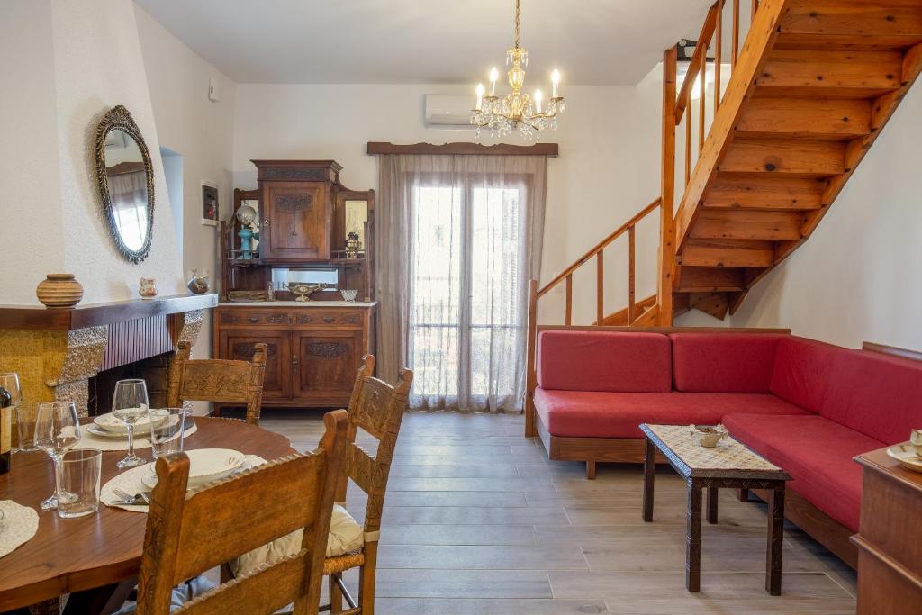 ein Wohnzimmer mit einem roten Sofa und einem Tisch in der Unterkunft Evelina's House in Platanias