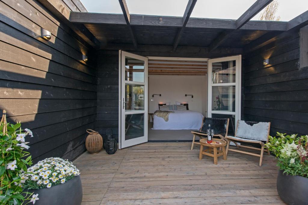 a bedroom with a bed on a wooden patio at Studio Haarlemenmeer in Cruquius