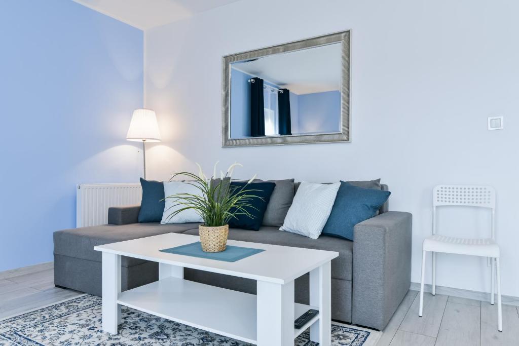salon z kanapą i lustrem w obiekcie LTC Apartments Malczewskiego Centrum w Gdańsku