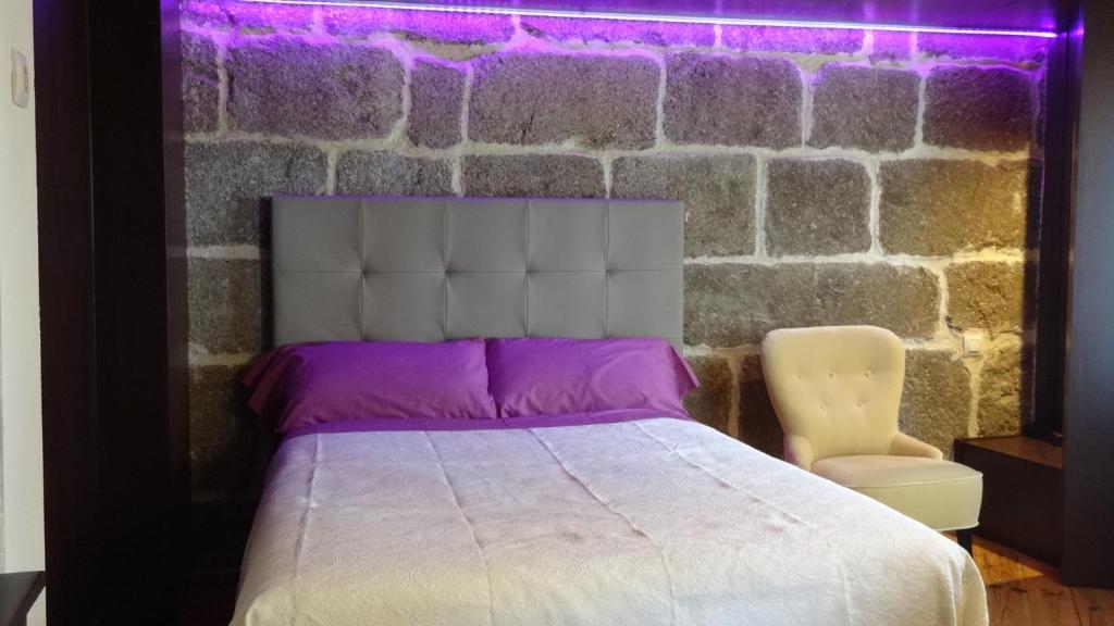 - une chambre avec un lit et un mur en briques dans l'établissement La Casita de Cayetana, à Piedrahíta