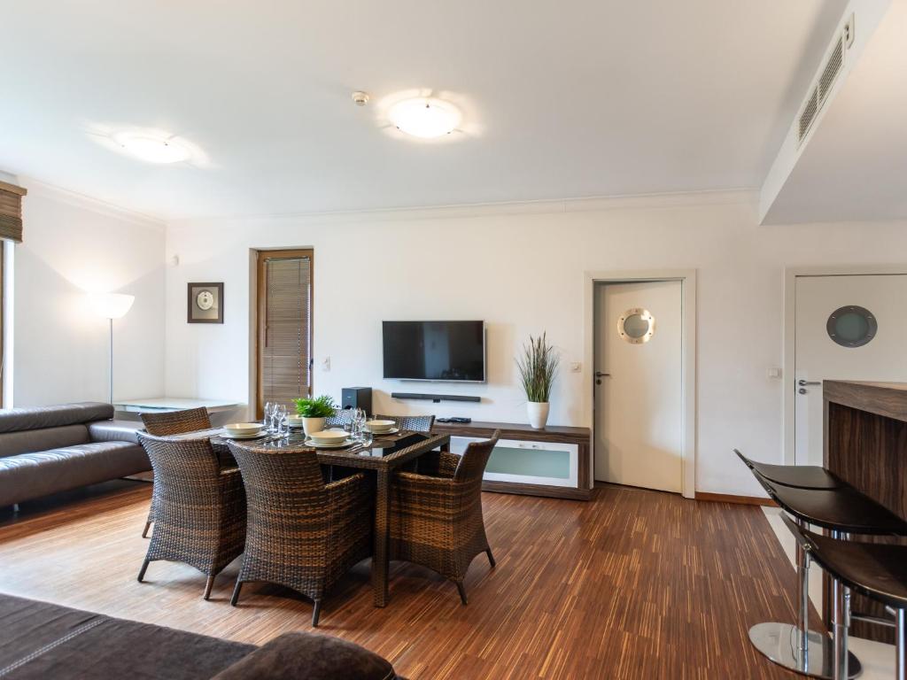 ein Wohnzimmer mit einem Tisch, Stühlen und einem Sofa in der Unterkunft VacationClub – Olympic Park Apartament B8 in Kołobrzeg