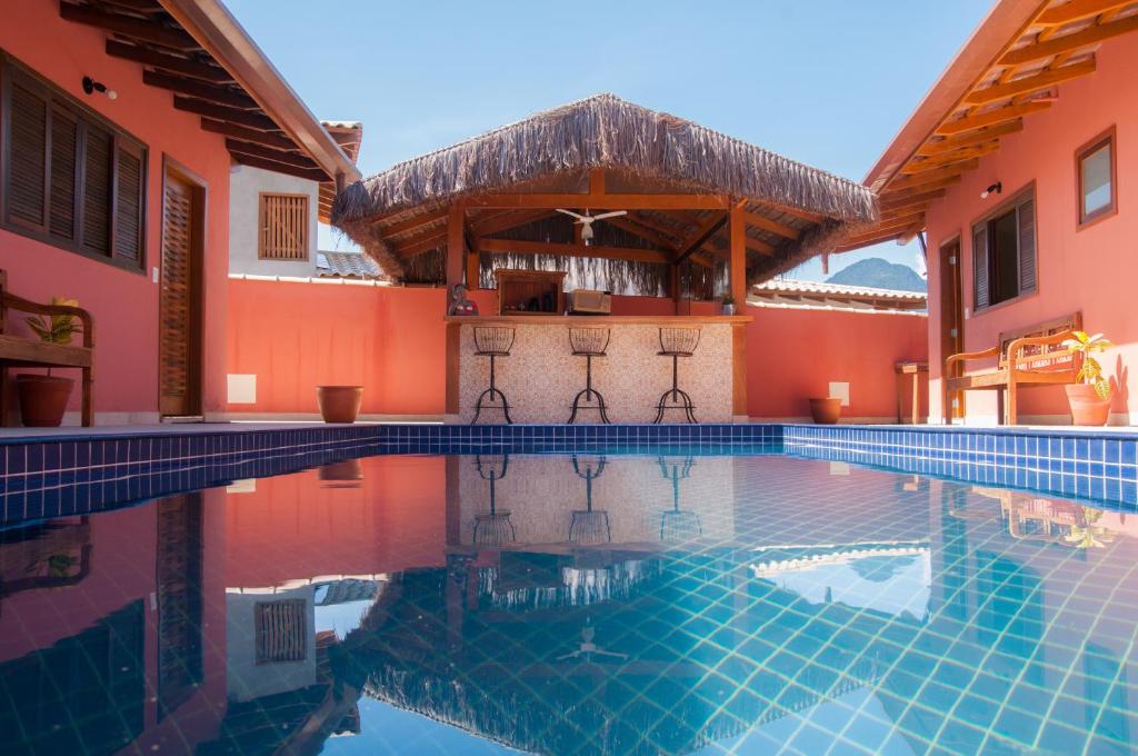 una piscina en el medio de una casa con un edificio en Suítes Yamamoto Ilhabela, en Ilhabela