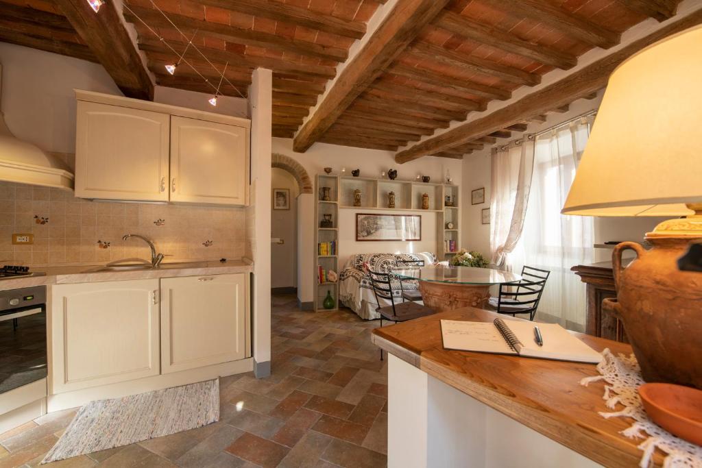 een keuken met witte kasten en een eetkamer bij La Casina di Pia in Montieri