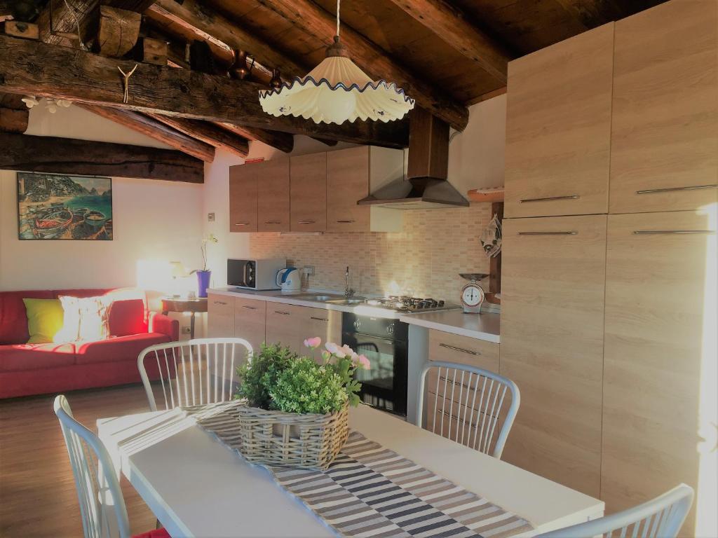 una cucina e un soggiorno con tavolo e sedie di Mansardino a Malcesine