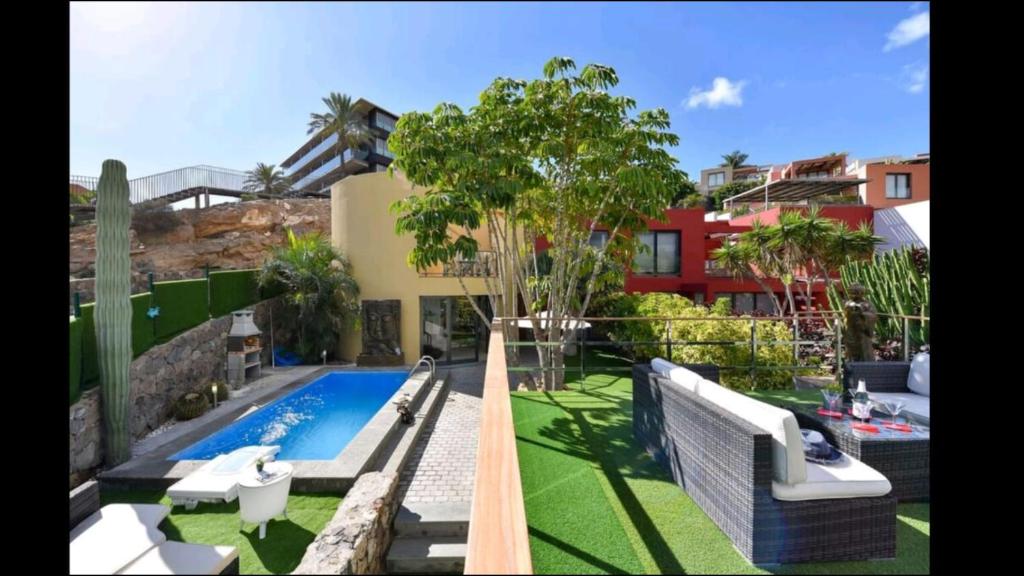 un patio trasero con piscina y una casa en Villa Las Terrazas 17•Exclusive Chill Out and Pool., en San Bartolomé