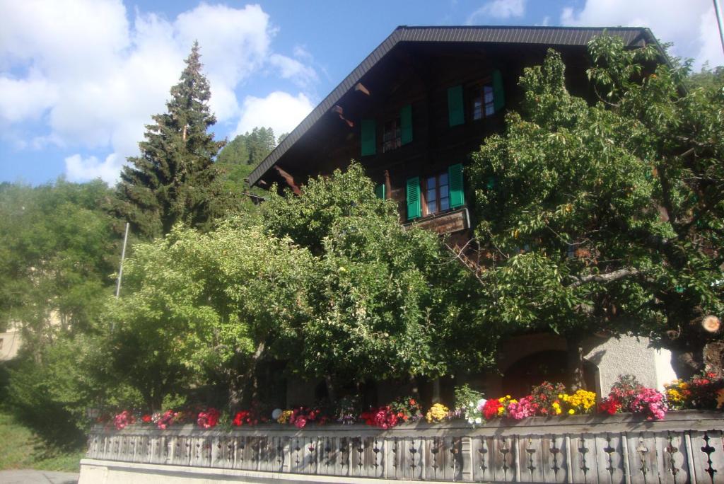 une maison avec des fleurs devant une clôture dans l'établissement Bietschhorn, à Kippel