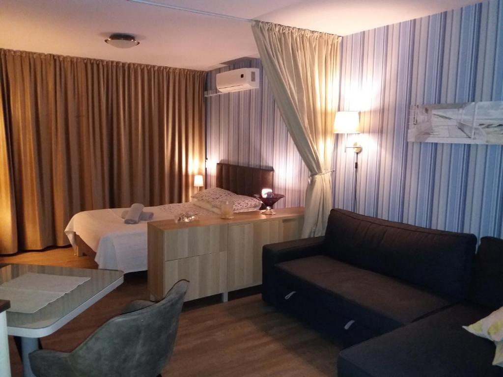 ブワディスワボボにあるApartament Tomulaのベッドとソファ付きのホテルルーム