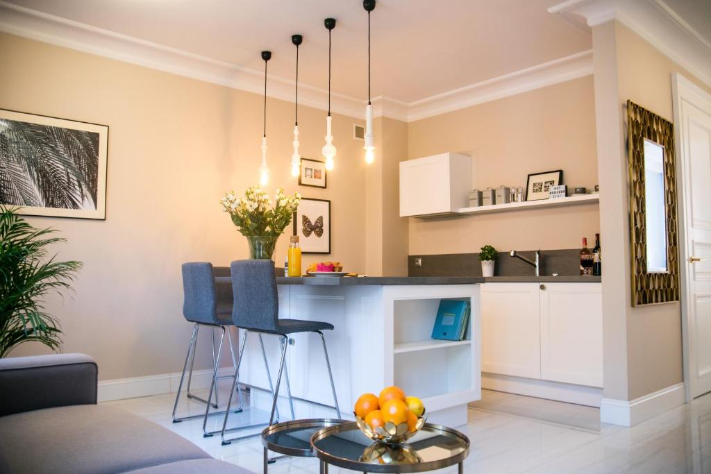 a kitchen and living room with a table and chairs at Rycerska - Stone Steps Apartments in Warsaw