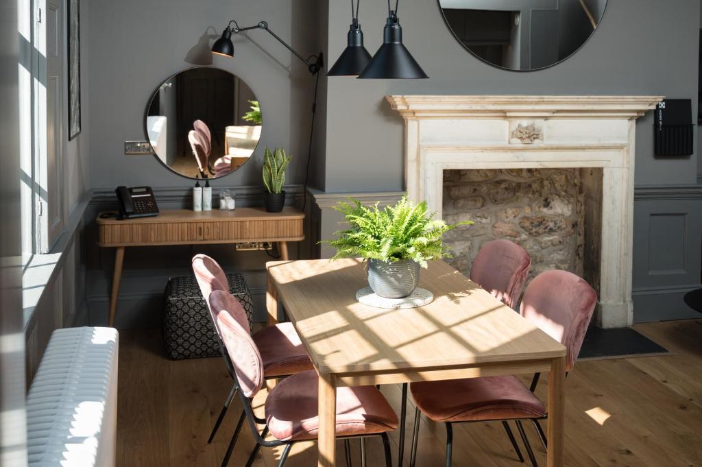 a dining room with a table and chairs and a mirror at Hiding Space - Trim Street Apartments in Bath