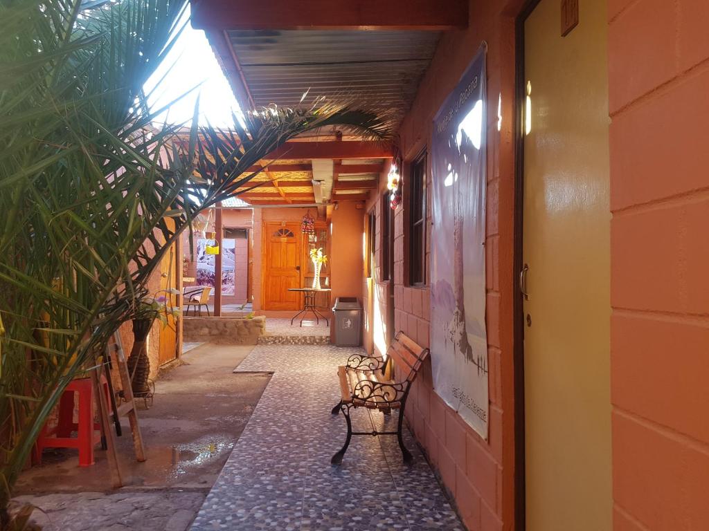 un corridoio con panchina accanto a un edificio di Hostal Tuyasto a San Pedro de Atacama