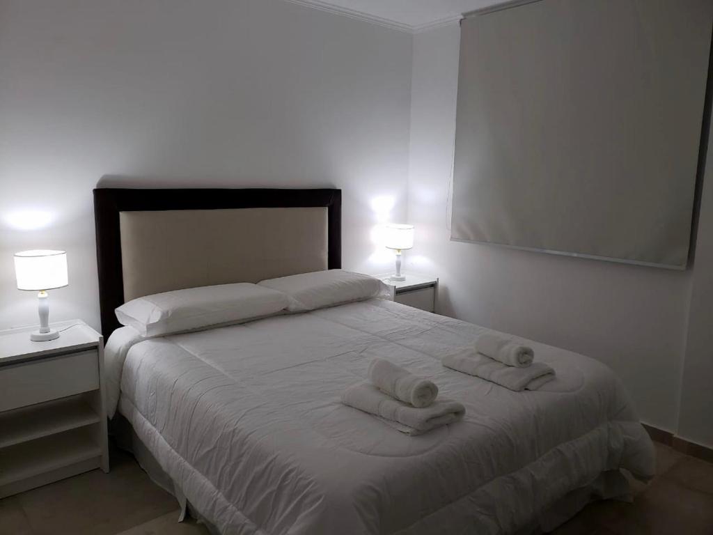 ein Schlafzimmer mit einem Bett mit zwei Handtüchern darauf in der Unterkunft Departamento Centrico in Villa María