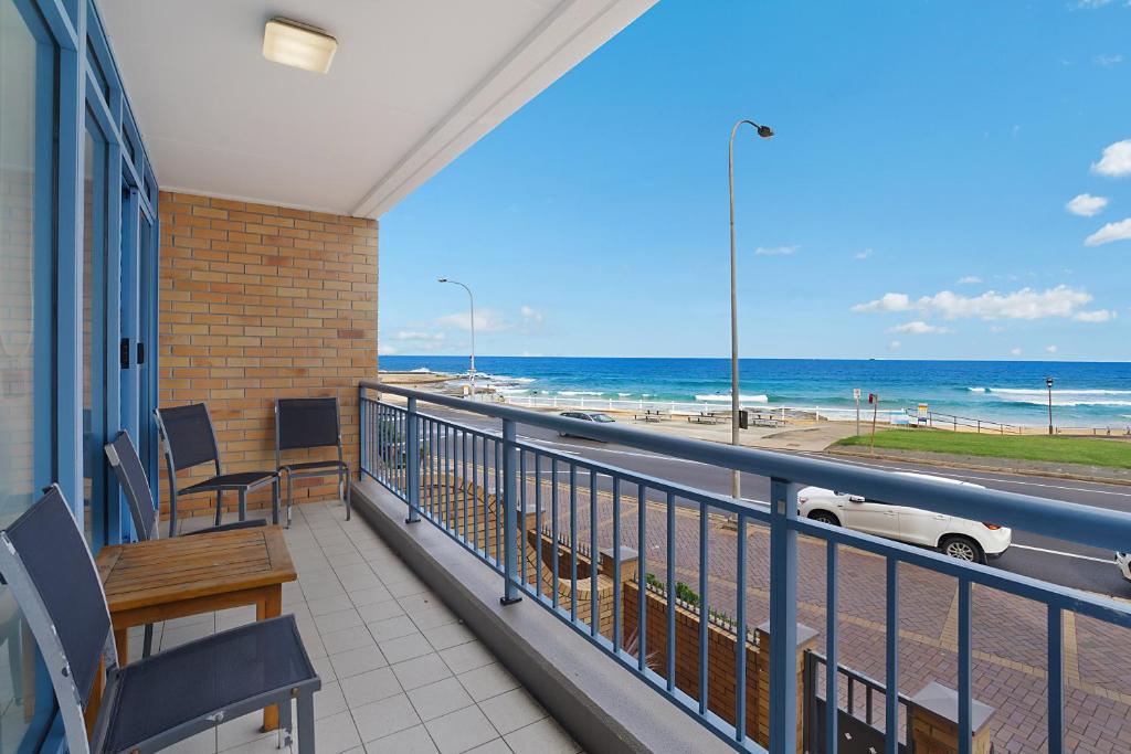 einen Balkon mit Blick auf den Strand und ein Auto in der Unterkunft Newcastle Short Stay Accommodation - Sandbar Newcastle Beach in Newcastle