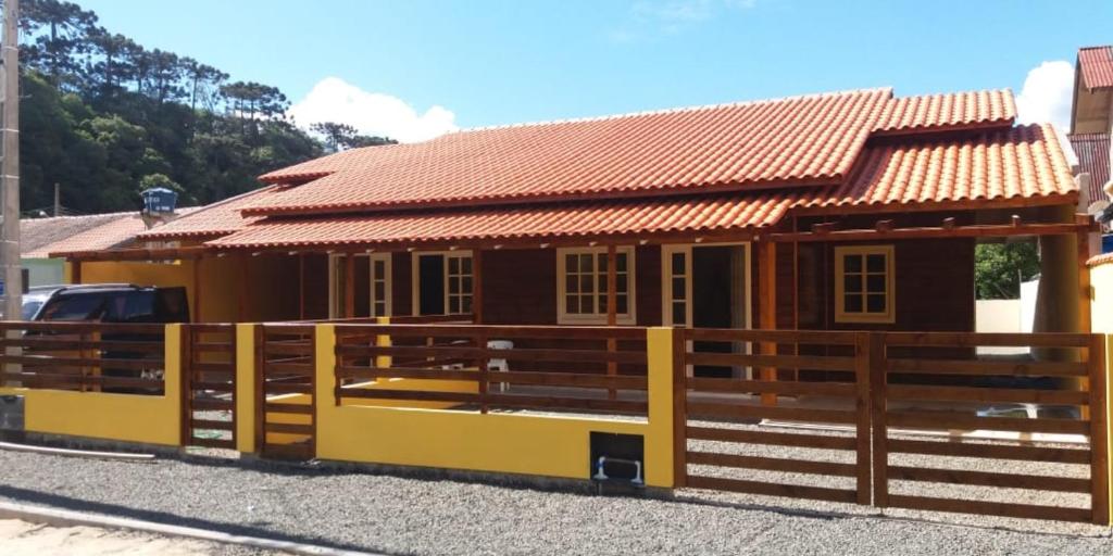 une petite maison avec une clôture devant elle dans l'établissement A Casa é Sua!, à Urubici