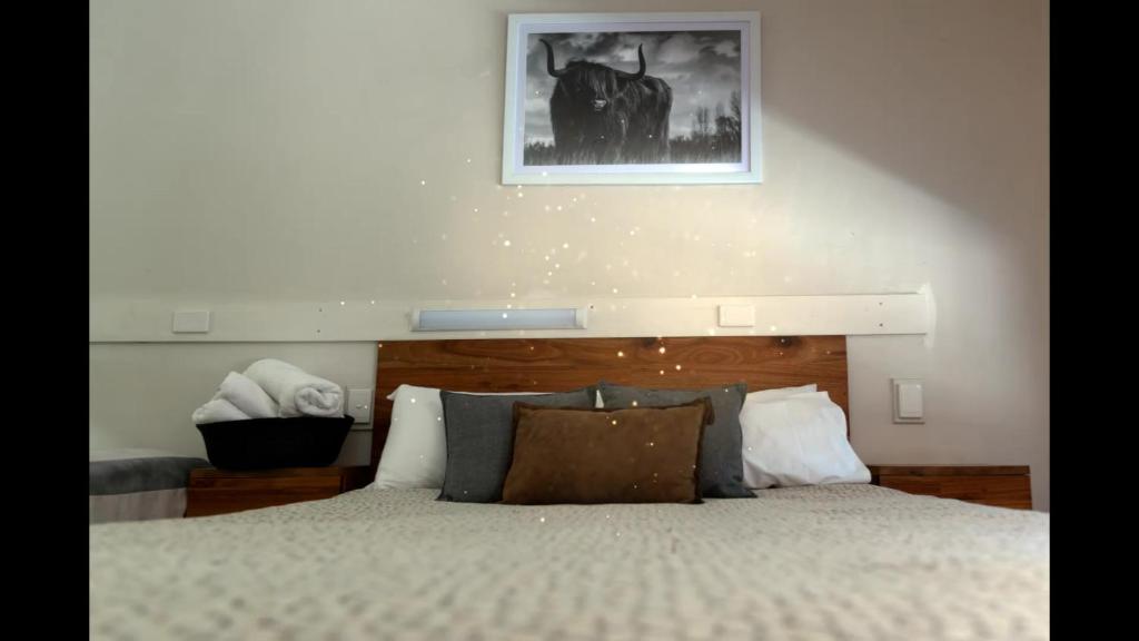 1 dormitorio con 1 cama y una foto en la pared en Black Forest Motel, en Macedon